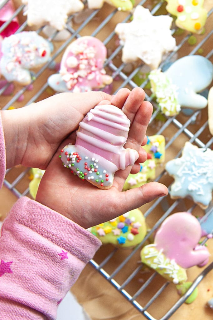 Little hands holding an iced sugar cookie.