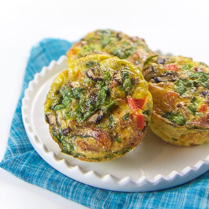 A white plate with three veggie egg muffins sitting on top.