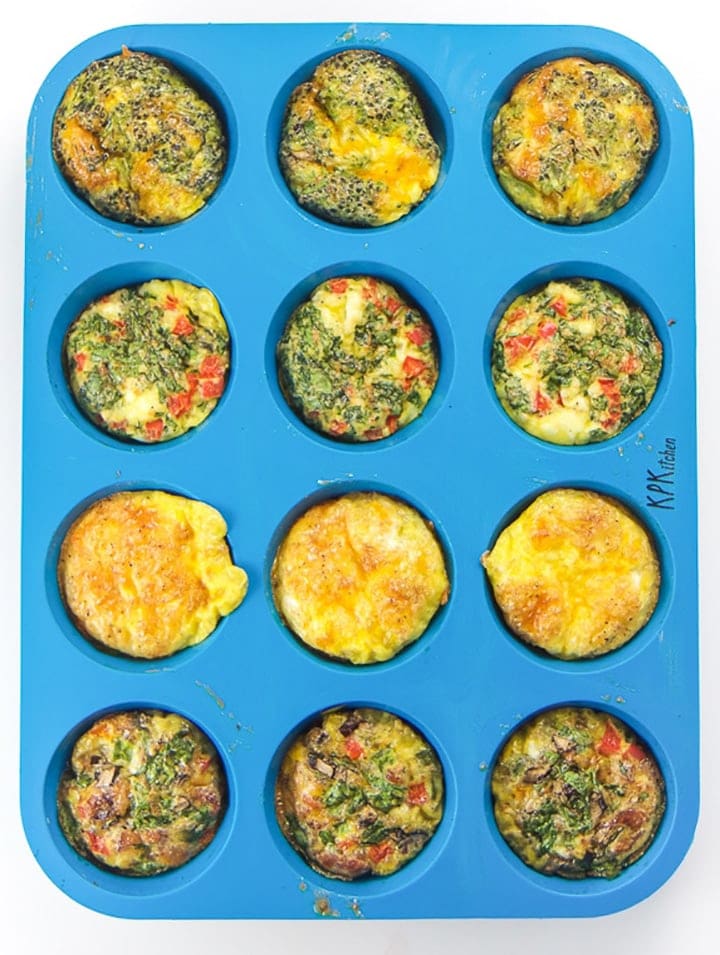 A blue silicone muffin tray with cooked egg muffins before varieties.