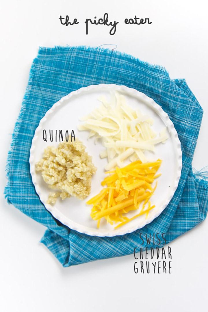 A small white plate with a small piles of cheese shredded and quinoa sitting on top.