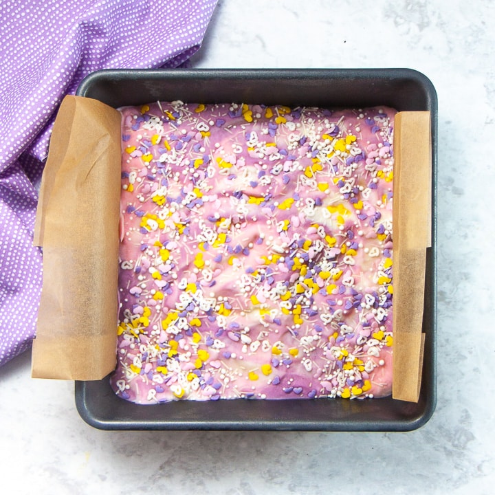 A square pan with frozen unicorn bark with sprinkles.