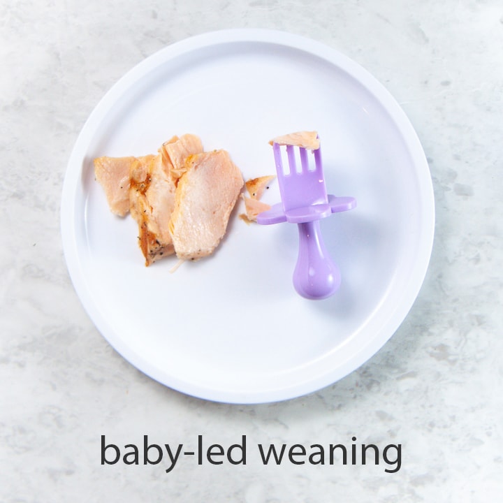 flakes of salmon on a plate with a fork for baby led weaning