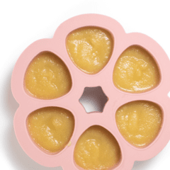 Pink baby food storage freezer container with. Apples.