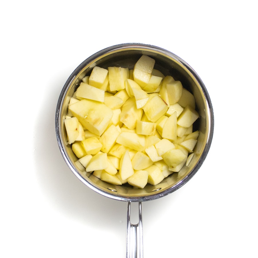 Silver sauce pan with chopped apples.