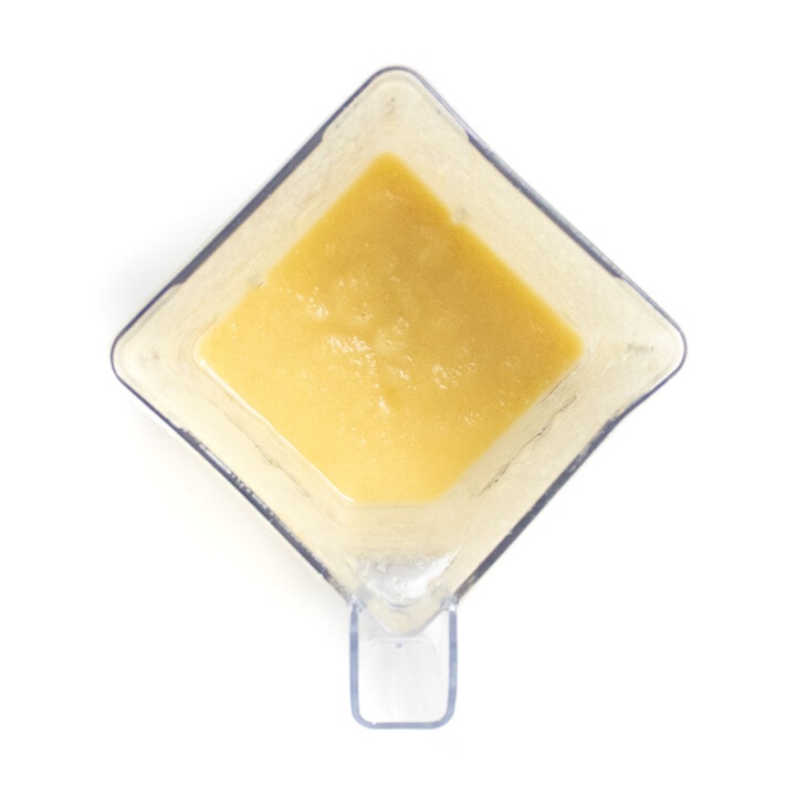 Clear blender on a white background with puréed apples.
