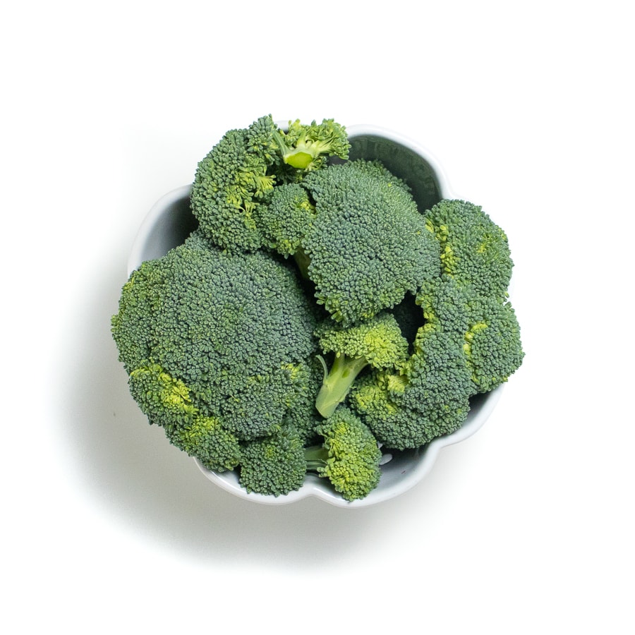 Bunches of broccoli in a white bowl. 