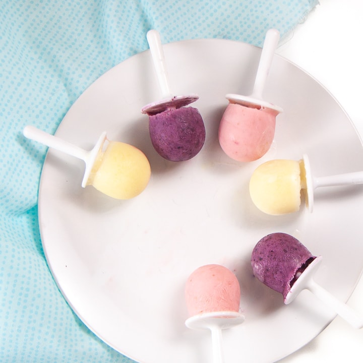 plate filled with yogurt popsicles in three different flavors.