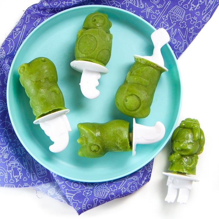 Green smoothie popsicles on a plate for toddlers and kids to grab.