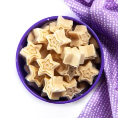 A purple bowl filled with star shaped peanut butter banana melts for baby.
