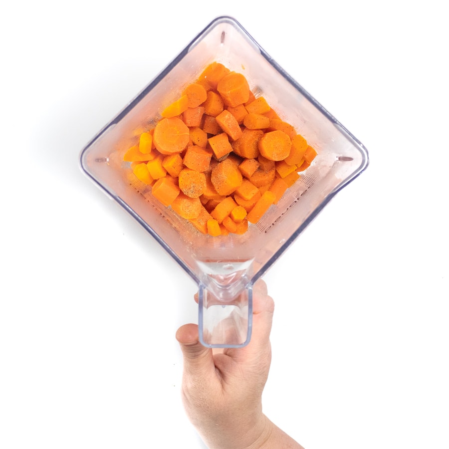 A blender with cooked carrots and a pinch of nutmeg.