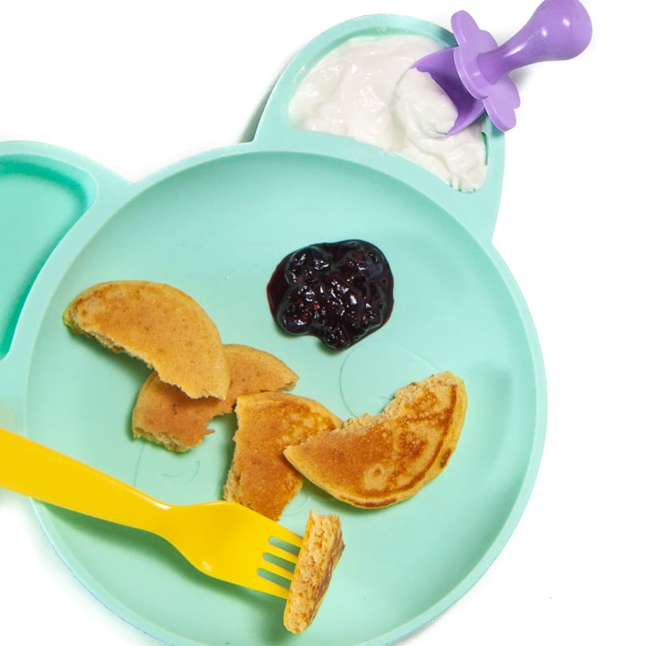 plate full of baby-led weaning pancakes cut into pieces with a fruit dip.