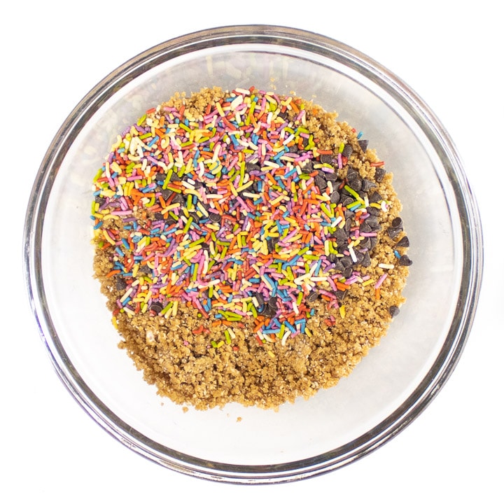 bowl of ingredients for energy balls with sprinkles and chocolate chips.