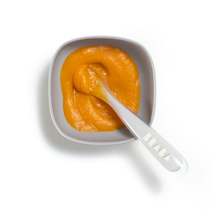 Gray baby bowl filled with a smooth sweet potato puree.