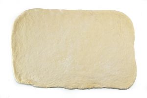 pizza dough rolled out into a rectangle.