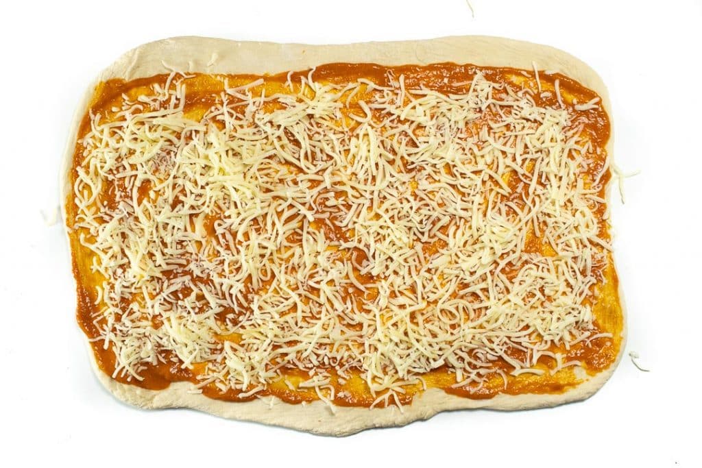 Pizza dough in a rectangle with hidden veggie sauce and cheese.