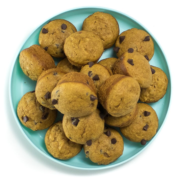 Plate of mini muffins with pumpkin and chocolate chips.