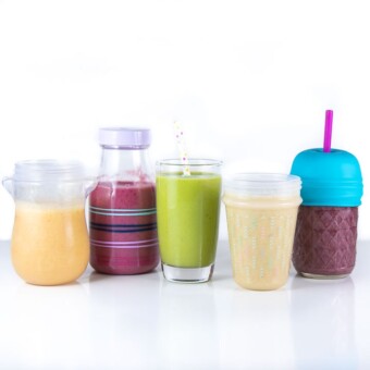 5 colorful smoothies lined up for baby to drink.