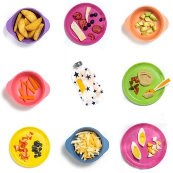 Grid of colorful kid plates with food for baby and toddler on it for snacks.