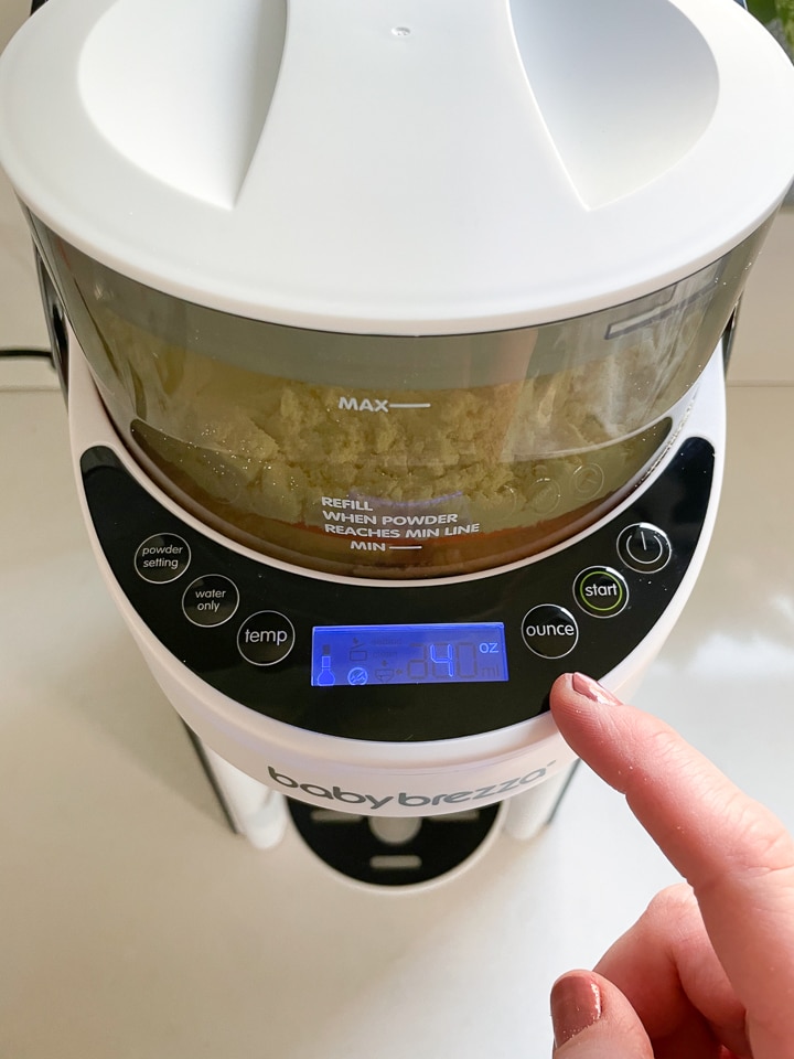 Finger pointing to the ounce setting on the baby Brezza.