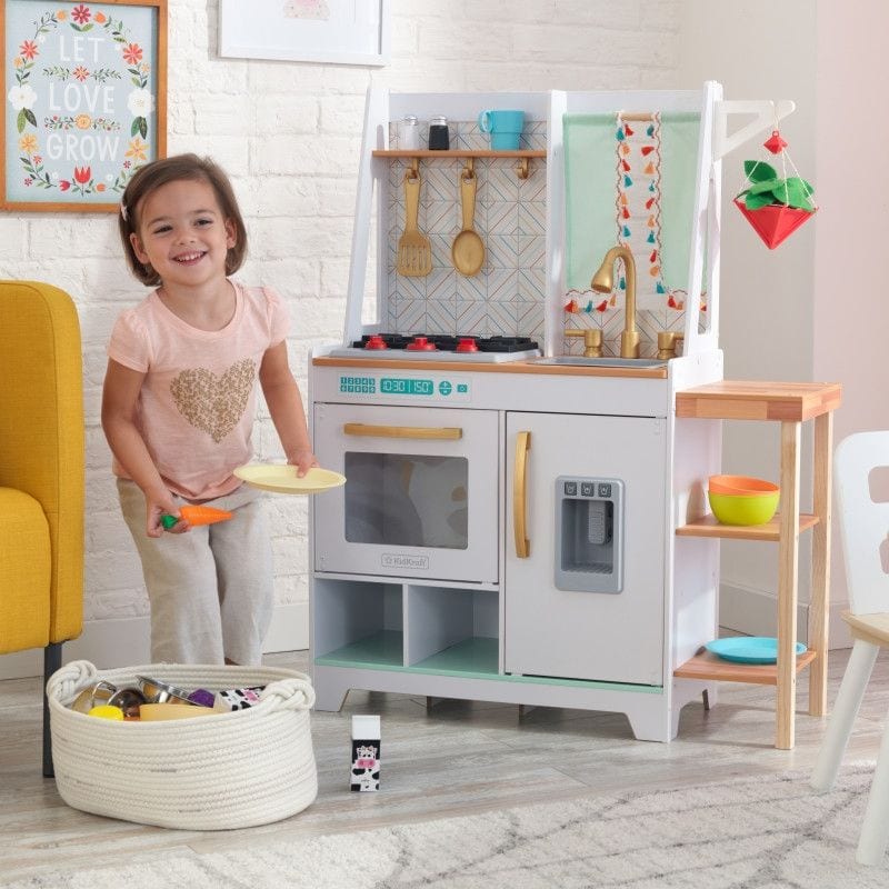Girls playing with a wood, white, teal and yellow play kitchen.
