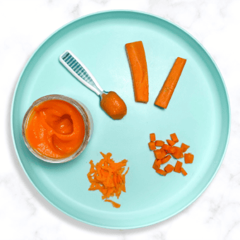 Blue baby plate on a white kitchen counter, with different ways to serve carrots to baby.
