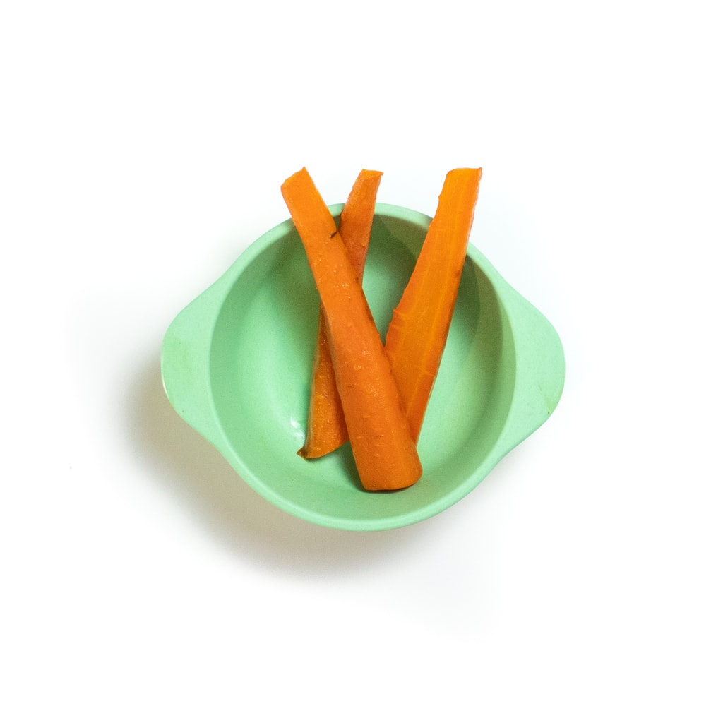 Teal baby bowl filled with roasted carrot sticks.