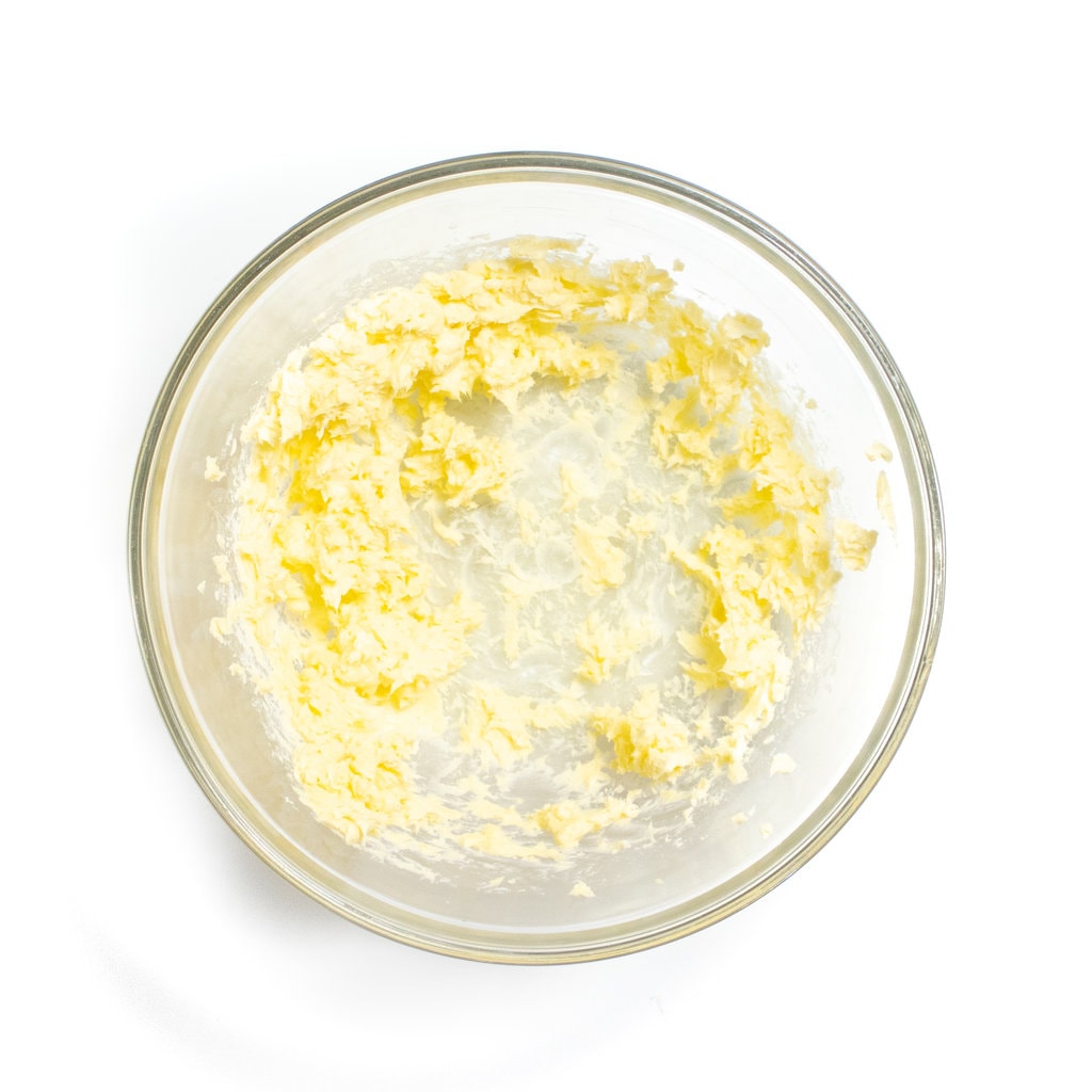 A glass mixing bowl with whipped butter.