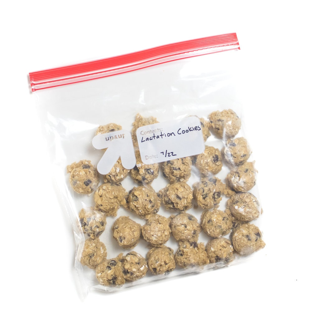 A freezer bag labeled lactation cookies with a date with frozen cookie scoops.