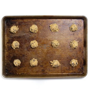 A used baking sheet with drops of lactation cookies on it.