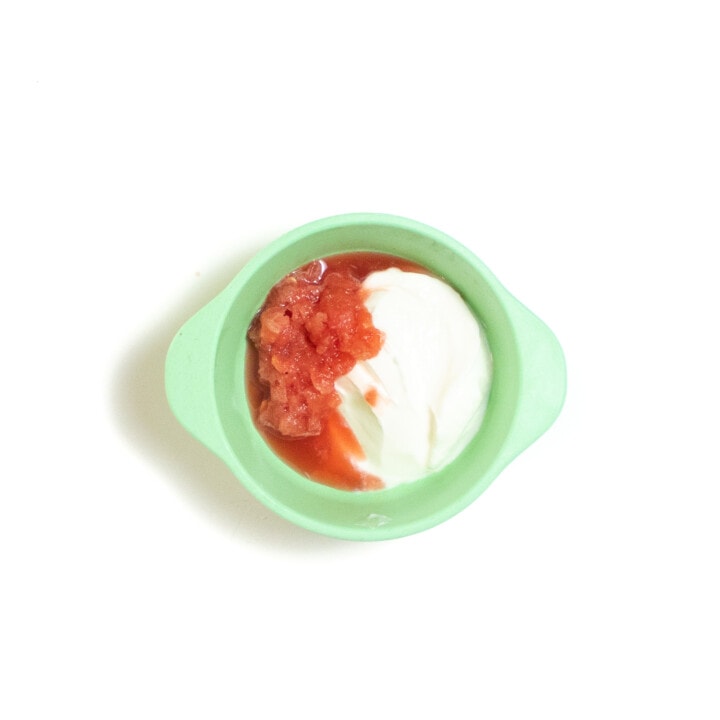 A teal baby bowl with chunky purée watermelon and yogurt.