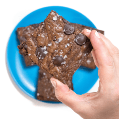 Graphic for post - a hand holding up a lactation brownie over a plate of brownies.