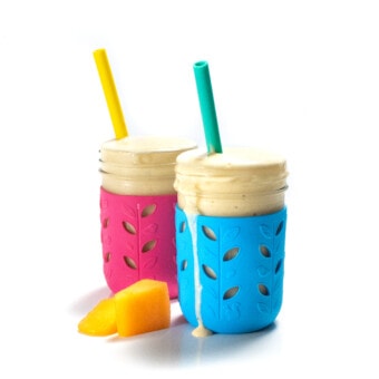 He said angle of a blue and pink kids cup with a yellow and teal straw with cantaloupe smoothie coming out of it.