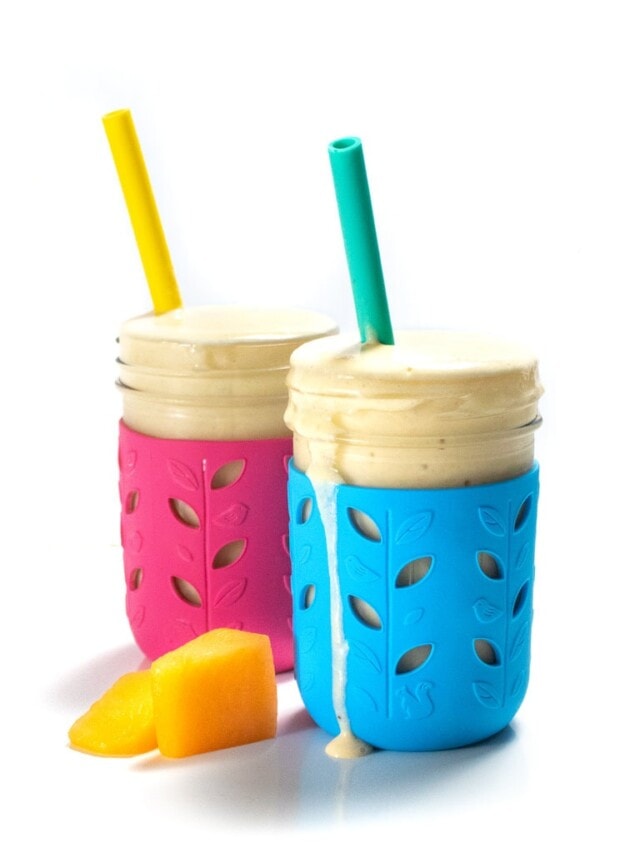 He said angle of a blue and pink kids cup with a yellow and teal straw with cantaloupe smoothie coming out of it.