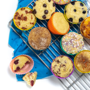 A cooling rack with pancake muffins with different toppings against a white background with blue napkin.