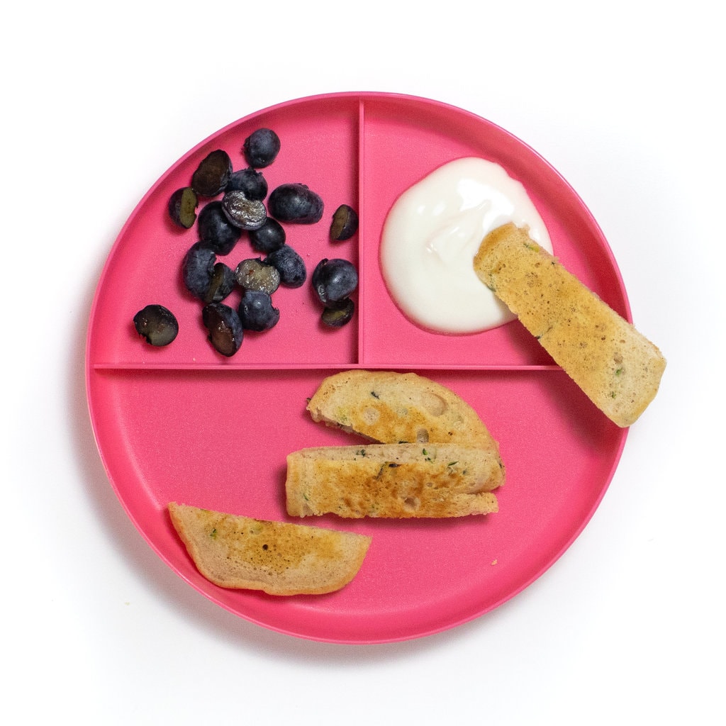 A pink kids plate showing how to serve these pancakes for baby led weaning and toddlers.