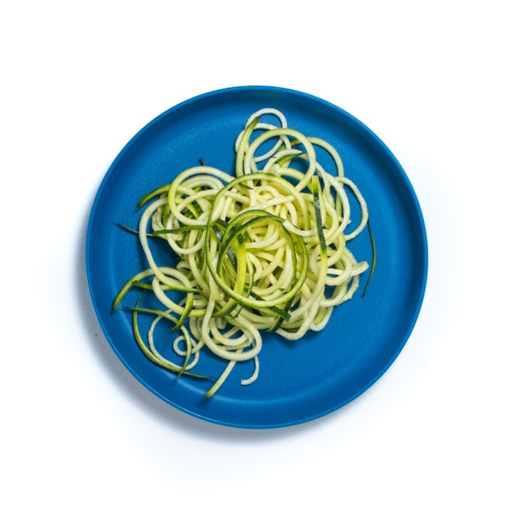 A blue plate with zucchini noodles.