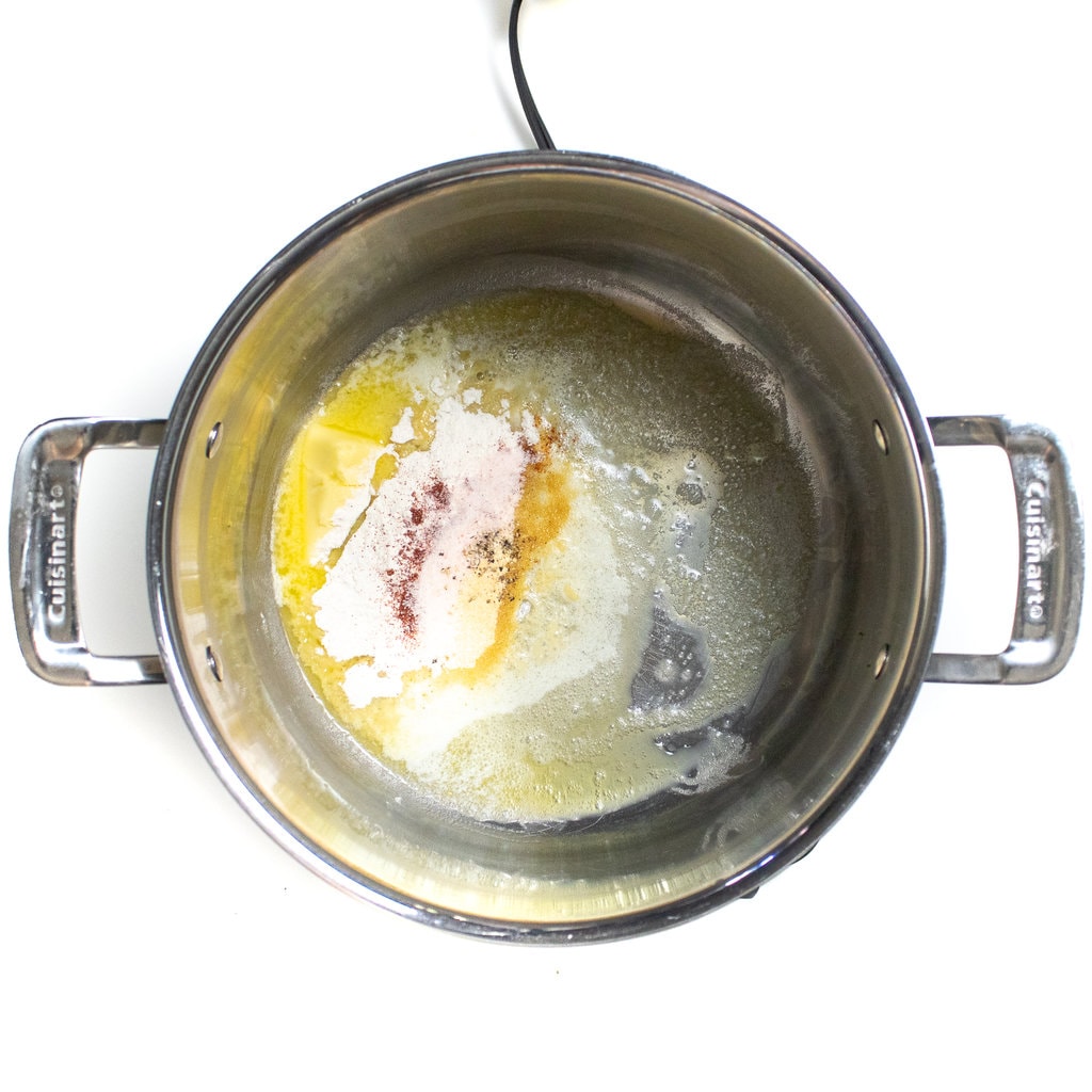 A large silver pot with butter, flour, spaces in salt.