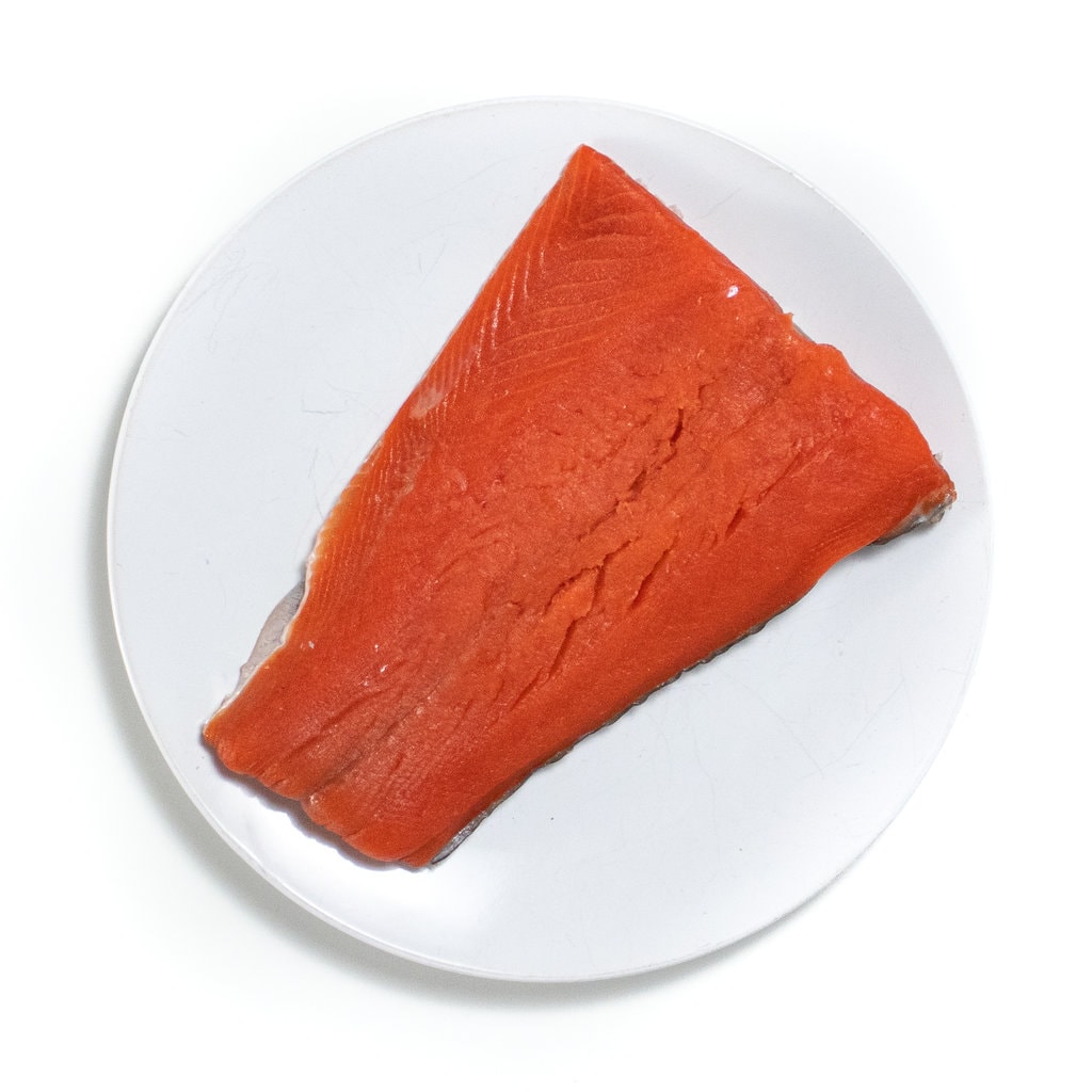 Piece of salmon on a white plate. 