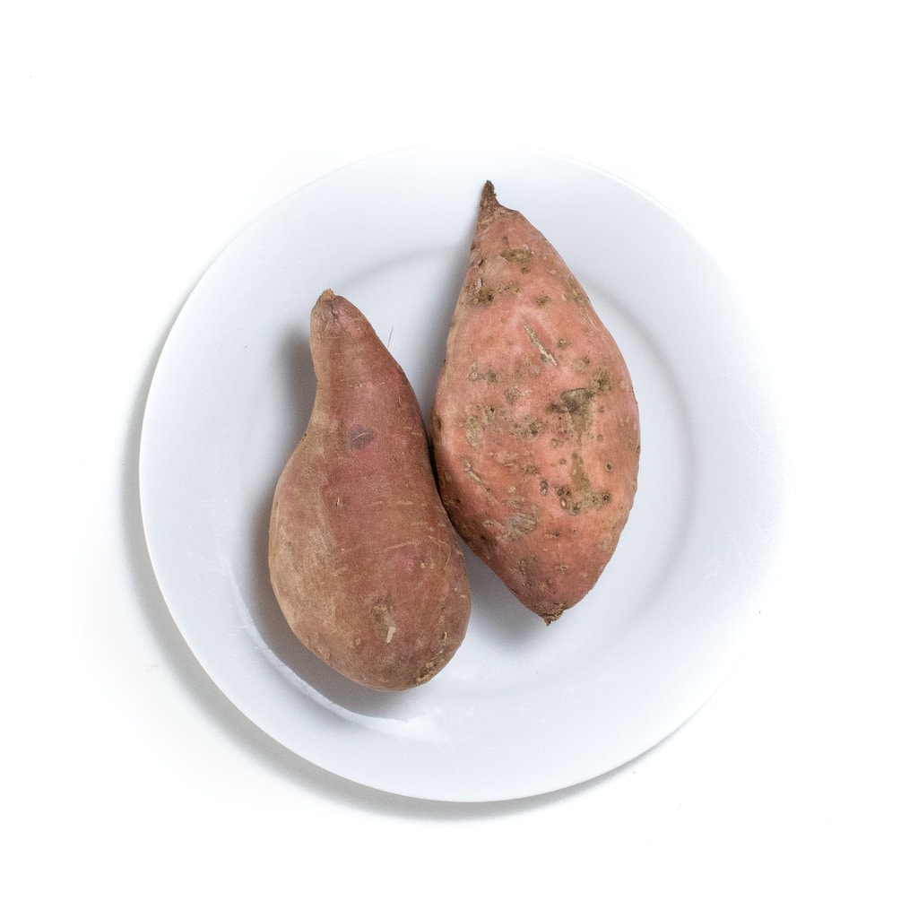 A white plate with two sweet potatoes on it