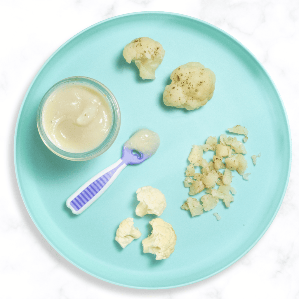 Teal baby plate with several ways to cook and serve cauliflower to your baby. Plate is sitting on a my white marble kitchen counter. 
