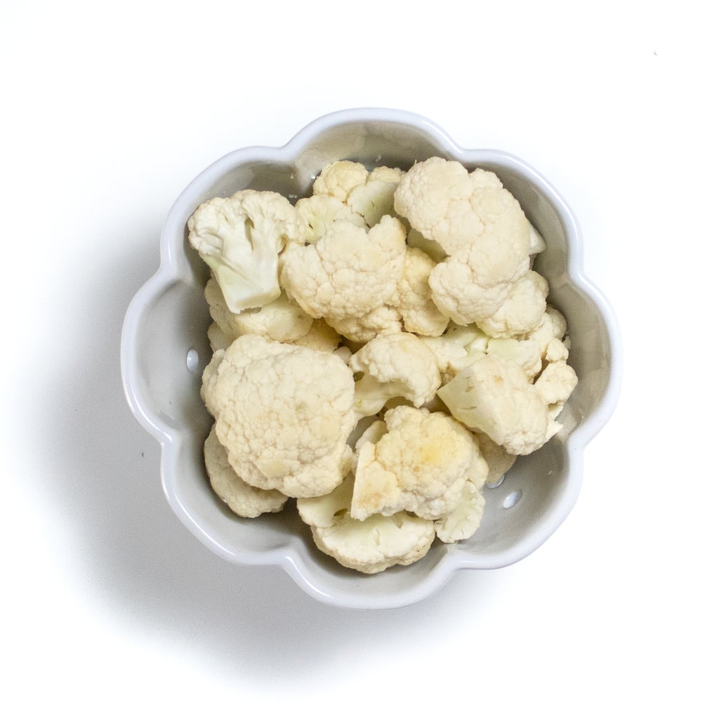 A white bowl full of cauliflower florets.