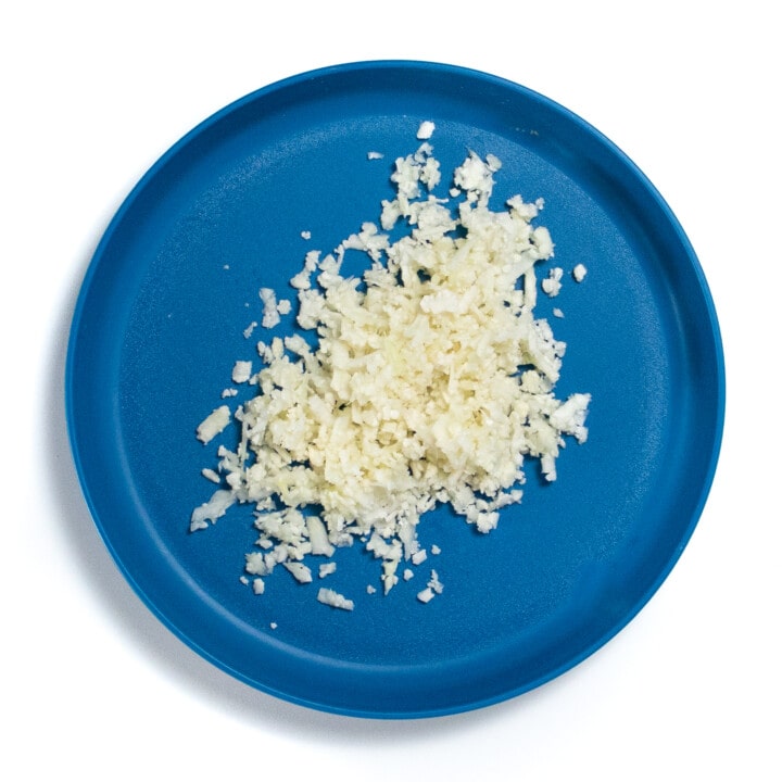 A blue plate with rice cauliflower.