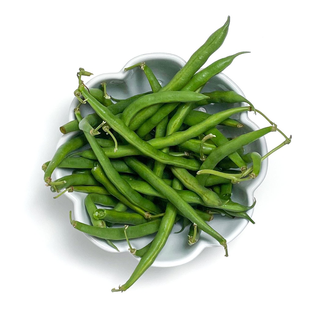 White bowl filled with fresh green beans. 