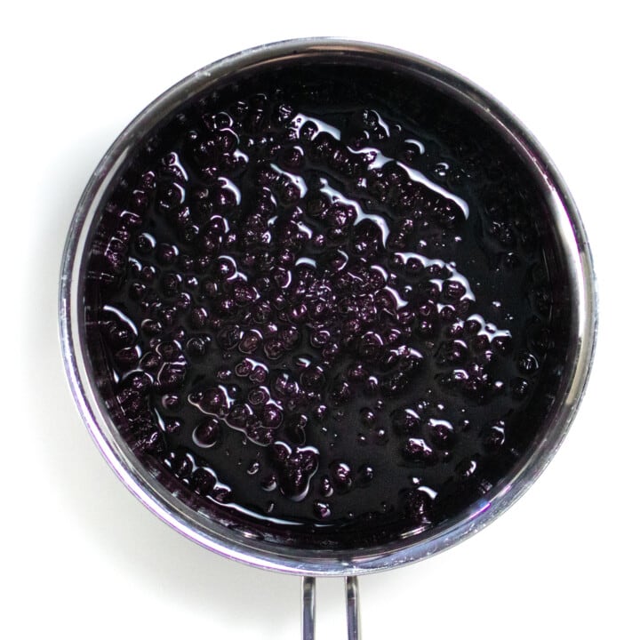Hey silver sauce pan full of frozen blueberries simmered down with maple syrup, and vanilla extract.