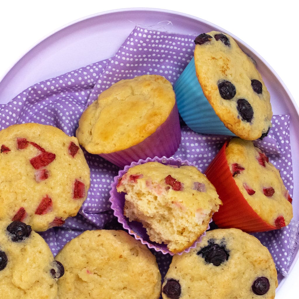 A purple plate and purple napkin with yogurt muffins on top.