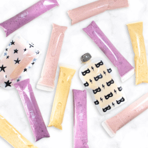 three different flavors of homemade yogurt tubes and pouches sitting on a white marble counter.