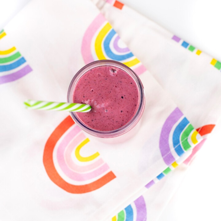 Colorful rainbow napkin with a mixed berry yogurt drink.