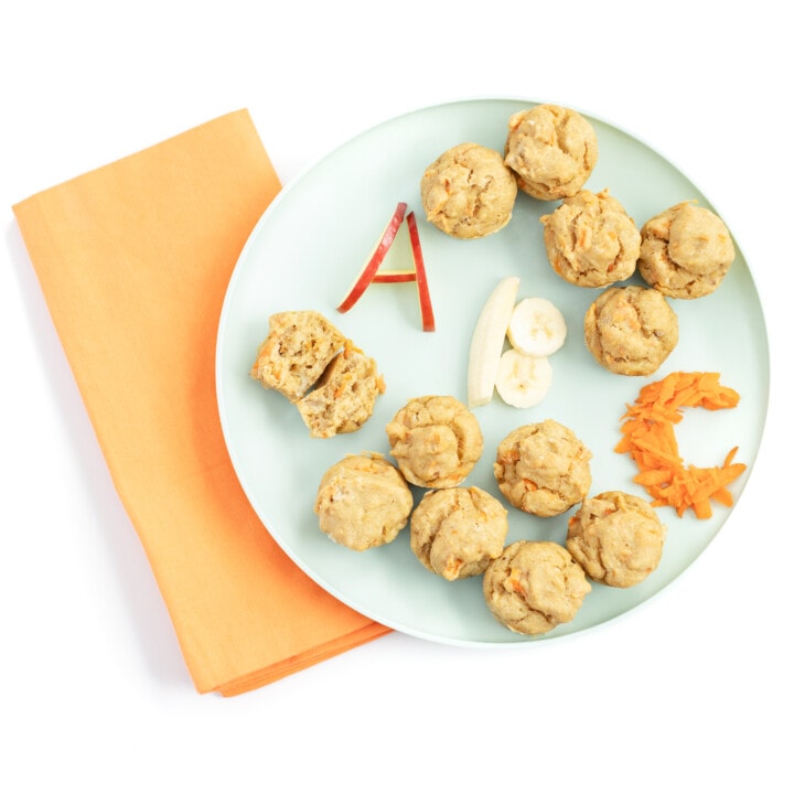 Teal kids play with ABC muffins with the letters a, B, C written out in Apple, banana and carrots again say marble background with a orange napkin.