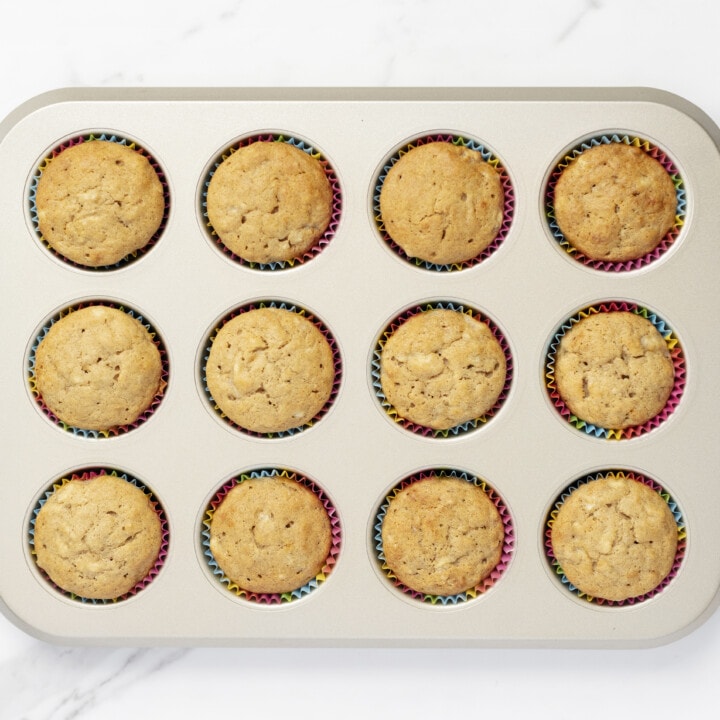Muffin pan with cooked banana muffins in them.