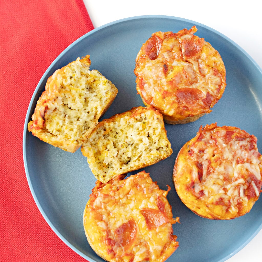 A gray kids plate with a red napkin on a white background. The plate has four pizza muffins on top.